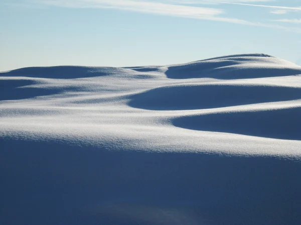 Солнечные дюны свежего снега — стоковое фото