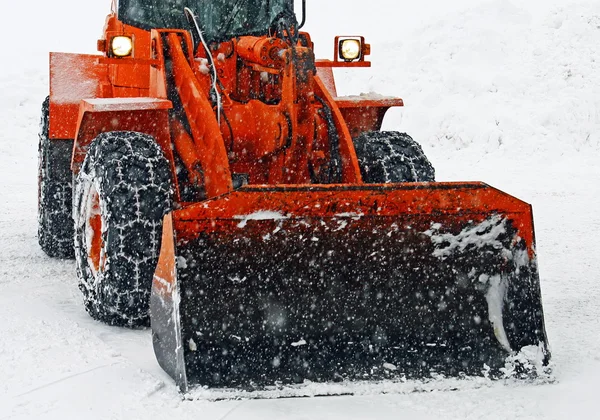 Orange snöplogen rensar gatorna under en snöstorm — Stockfoto