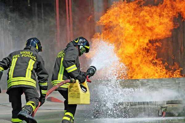 Bombeiros extingue um perigo de incêndio durante um exercício de treinamento no f — Fotografia de Stock