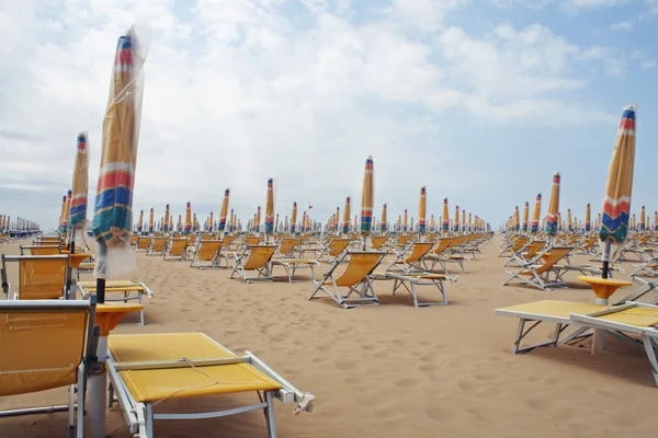 椅子、傘は 1 日で砂浜に沿ってラインでの閉集合 — ストック写真