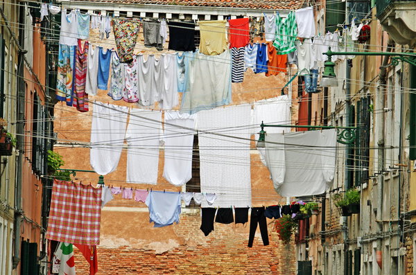 Street in venice with washing hung out to dry in the sun over the water cha