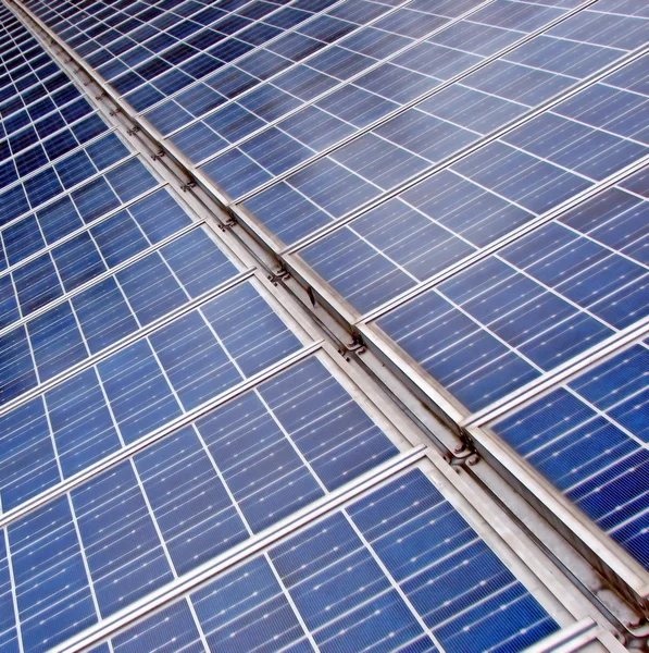 Larga fila interminable de paneles solares azules para producir electricidad — Foto de Stock