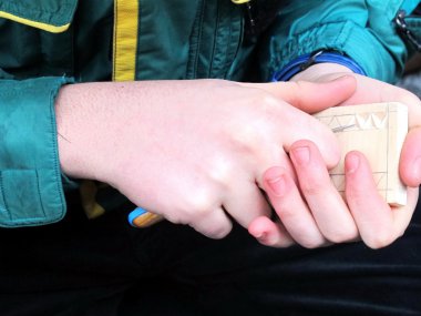 handen van de jonge beeldhouwer en hout werken