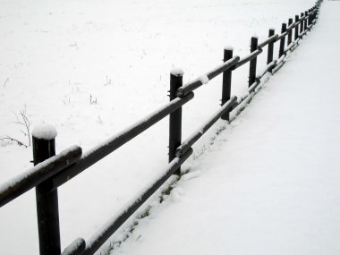 Wood fence covered with white snow in winter clipart