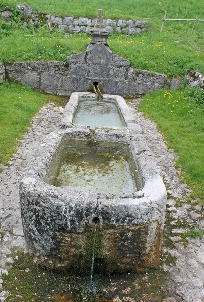 Fuente de piedra vieja con riego para lavar clo —  Fotos de Stock