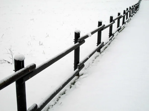 Cerca de madeira coberta com neve branca no inverno — Fotografia de Stock