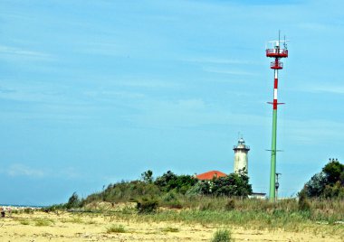 New and old lighthouse beacon on a sandy beach clipart
