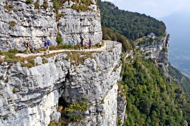 Family walks in the mountains on the edge of the ravine clipart