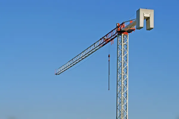 Высокий кран и сталь, используемые на строительной площадке — стоковое фото