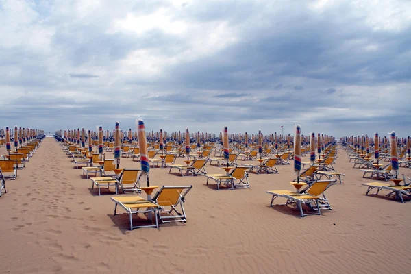 stock image Chairs, beach chairs and umbrellas closed in a line