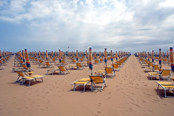 Стільці, пляжні стільці і парасольки закриті в лінії — стокове фото