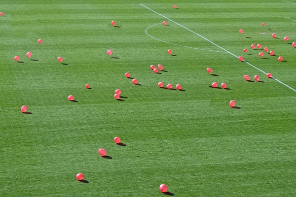 Balões cor-de-rosa voando sobre a grama do estádio — Fotografia de Stock
