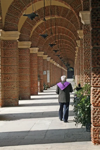 Prästen går längs gallerierna av en kyrkogård — Stockfoto