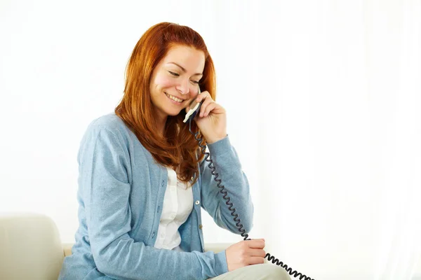 Mulher bonita sorrindo e usando um telefone — Fotografia de Stock