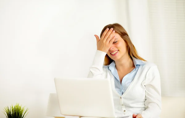 Mulher rindo sozinha enquanto está usando no laptop — Fotografia de Stock