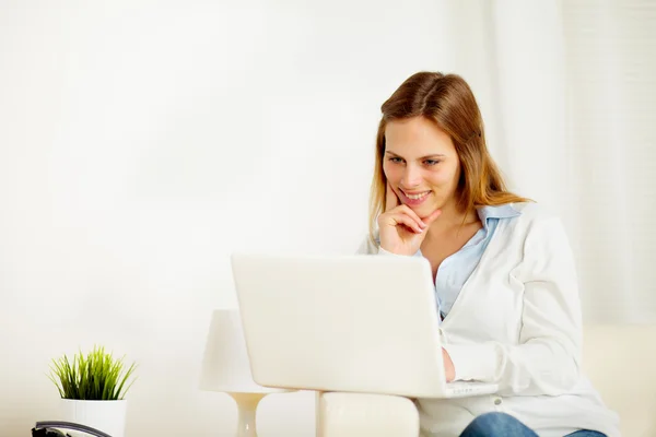Smiling woman using on laptop Stock Photo