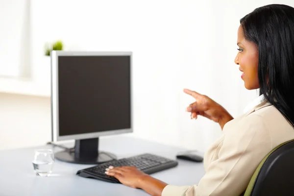 Businesswoman pointing to a monitor — Stock Photo, Image