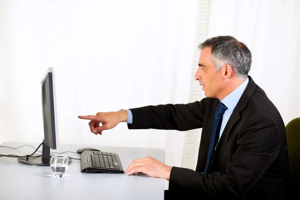 Бизнесмен, указывающий на компьютер — стоковое фото