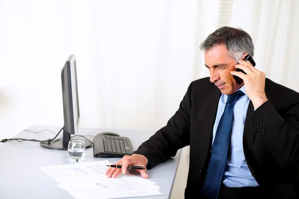 Бизнесмен выступает на мобильном телефоне в офисе — стоковое фото