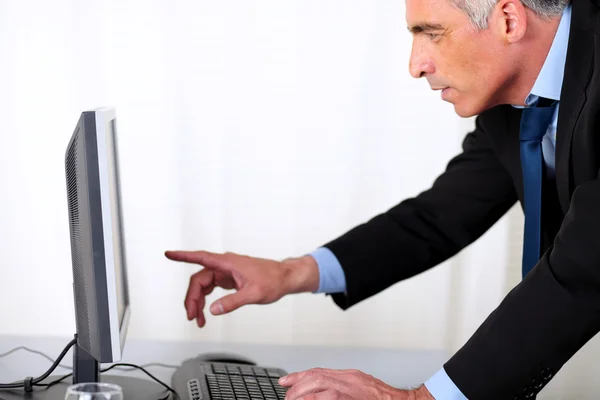 Элегантный бизнесмен, указывающий на компьютер — стоковое фото