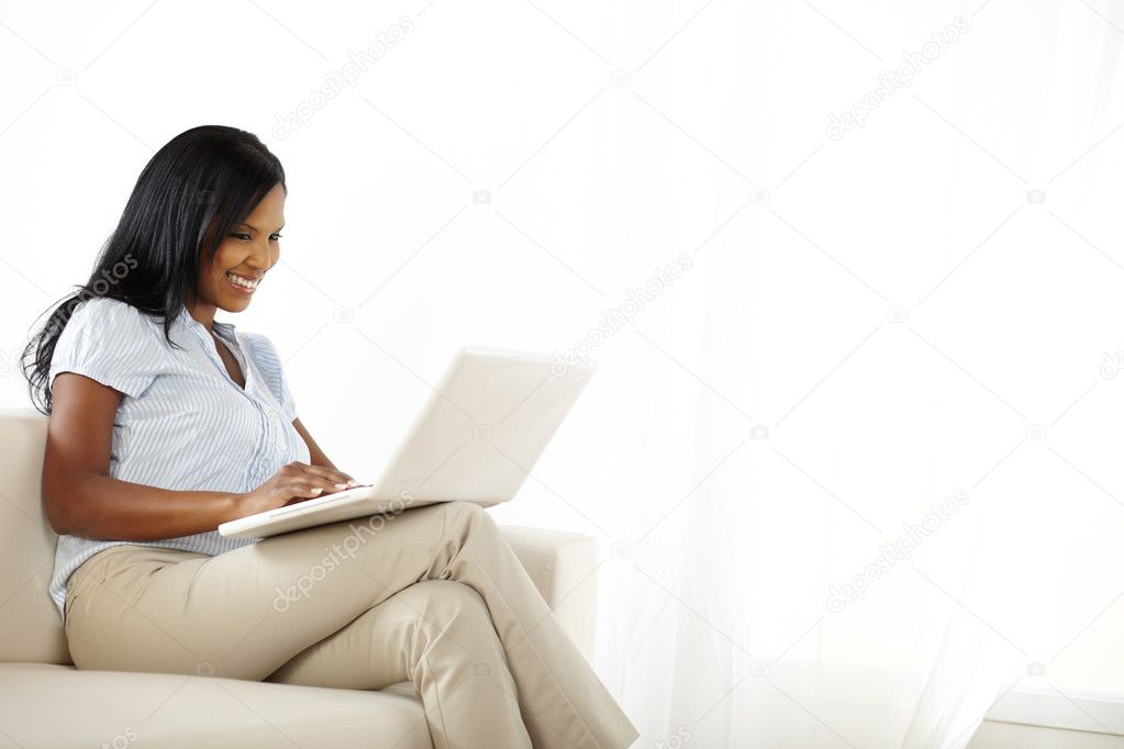 Pretty happy young woman using a laptop