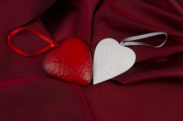 Красные и белые сердца на атласе — стоковое фото