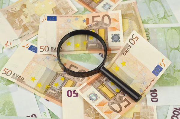 Magnifying glass on money background — Stock Photo, Image