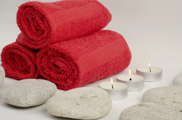 Rote Handtücher mit Steinen und Kerzen Stockbild