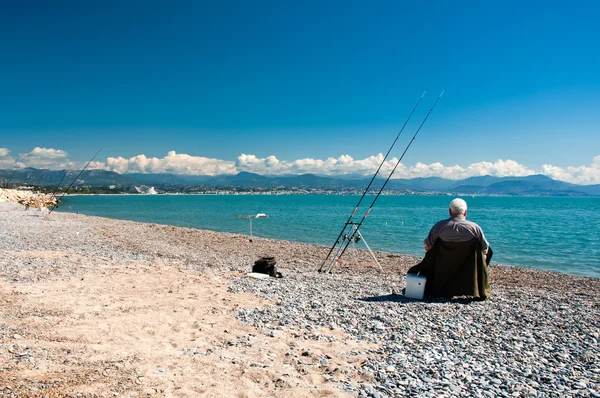 Fisherman at blue sea coast during sunny day Royalty Free Stock Photos