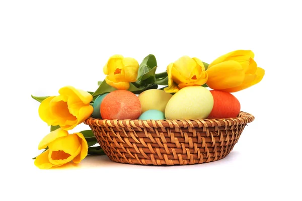 Пасхальные яйца в корзине с тюльпанами — стоковое фото