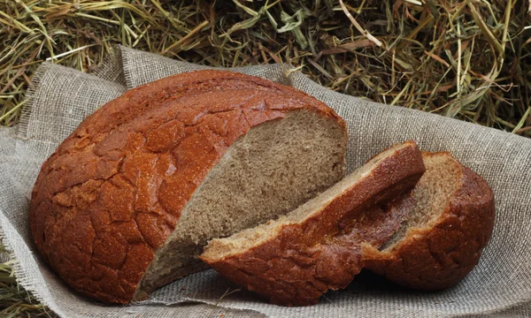 Brun skivat bröd på hö — Stockfoto