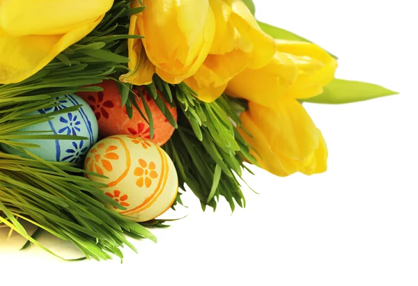 Easter eggs in grass with tulips — Stock Photo, Image