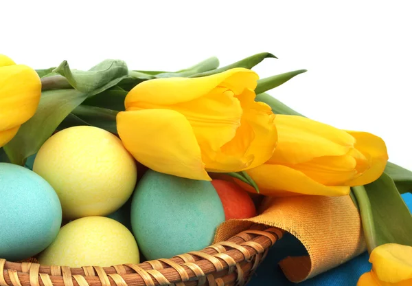 Пасхальные яйца в корзине с тюльпанами — стоковое фото