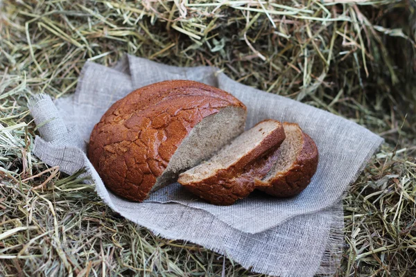 Pan rebanado marrón sobre heno — Foto de Stock