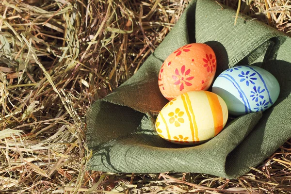Velikonoční vajíčka a textilní na seno — Stock fotografie