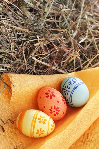 Пасхальные яйца и текстиль на сене — стоковое фото