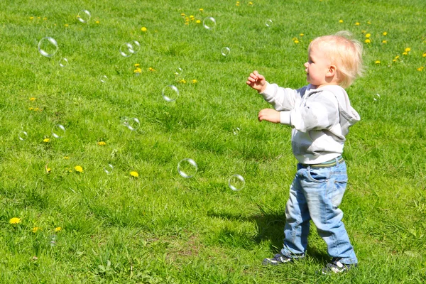 Дети ловят мыльные пузыри — стоковое фото