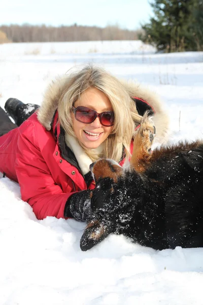Γυναίκα που παίζει με το σκυλί το χειμώνα — Φωτογραφία Αρχείου