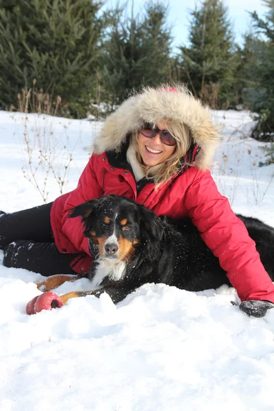 Donna con cane nella neve — Foto Stock
