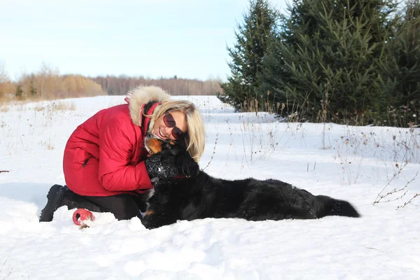 雪の中で犬を持つ女性 — ストック写真