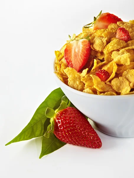 Bowl of cornflakes and strawberries on white background — Stock Photo, Image