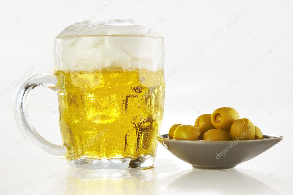 Fresh beer and olives over white background