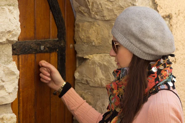 Femmes frappant à une vieille porte en bois — Photo