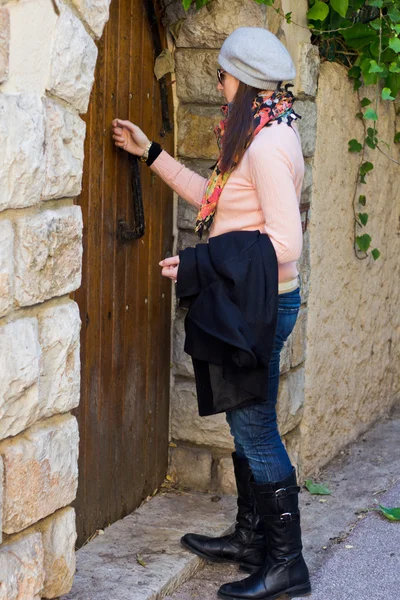古い木製のドアをノックの女性 — ストック写真