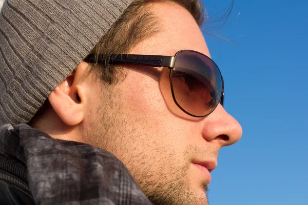 Brunetka człowiek z okulary przeciwsłoneczne i kapelusz patrząc — Zdjęcie stockowe