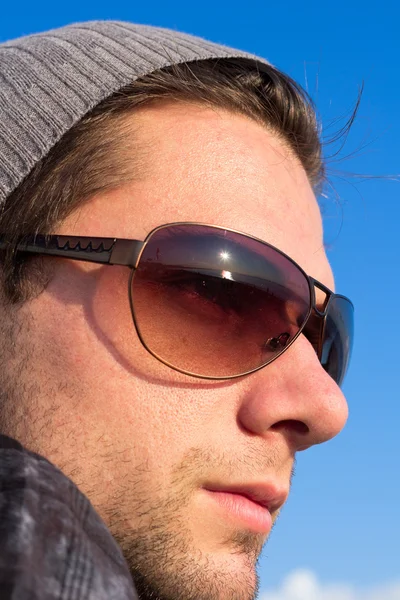 Bruna uomo con occhiali da sole e un cappello guardando — Foto Stock