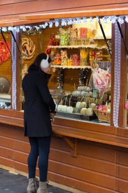 Brunette Woman Buying Candy At A Kiosk clipart