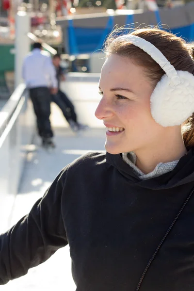 Junge brünette Frau mit Ohrenklappen lächelt — Stockfoto