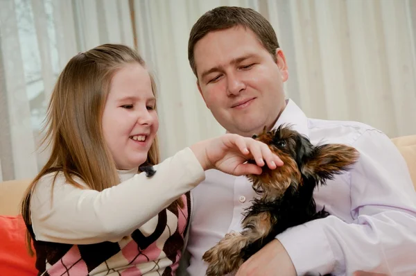 Lapsi isän kanssa leikkii koiran kanssa — kuvapankkivalokuva