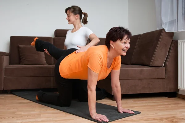 Entrenador ayudando a la mujer mayor ejercicio —  Fotos de Stock